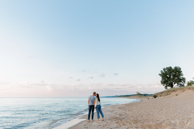 couple kissing next to lake michigan in the summer