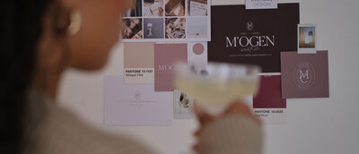 Woman drinking prosecco in front of a moodboard on a wall