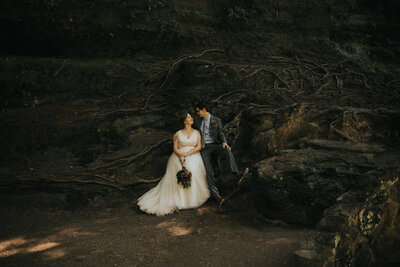 bride and groom sitting on a mountain