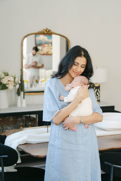 Philly mom holds her newborn baby during her photo session with AnneMarie Hamant