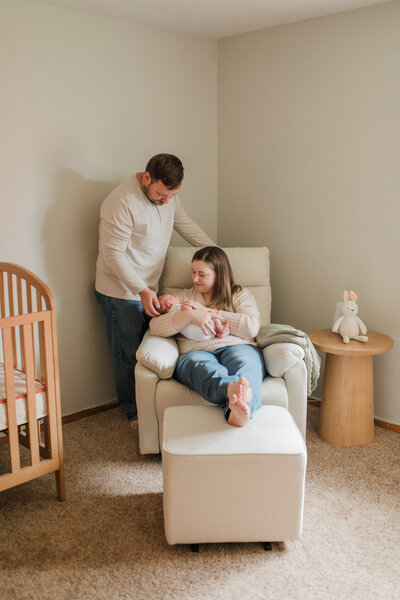 Portland Newborn Photographer _ newborn baby girl being held by her parents who are looking lovingly at her