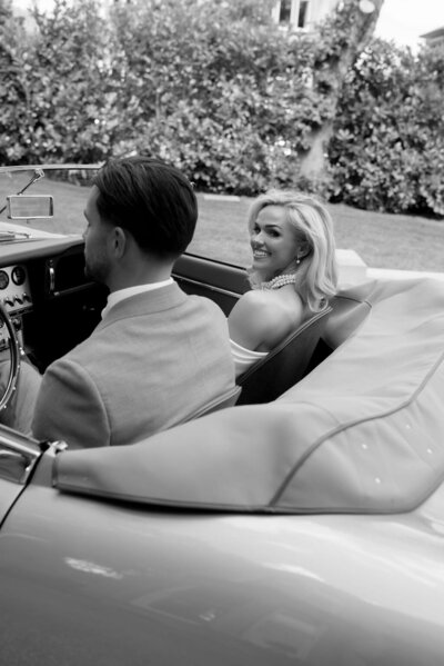 Couple in white car wearing sunglasses