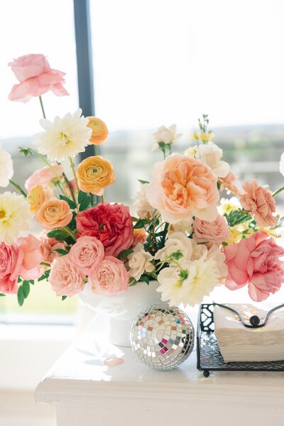 Chic floral arrangement with peach and blush tones styled for a corporate event or modern wedding in Austin, paired with disco decor.