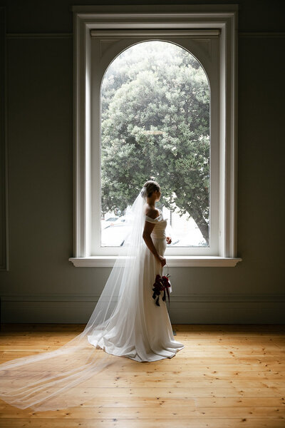 Bride & groom standing in the entry to their reception with elegantly styled wedding floral arrangements 