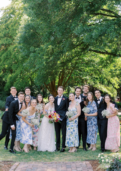 Group wedding party smiling. Summer wedding with bridesmaids and groomsmen smiling.