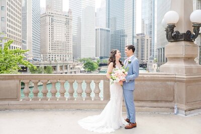 Spring wedding portrait of bride and groom over looking the river walk and downtown Chicago.