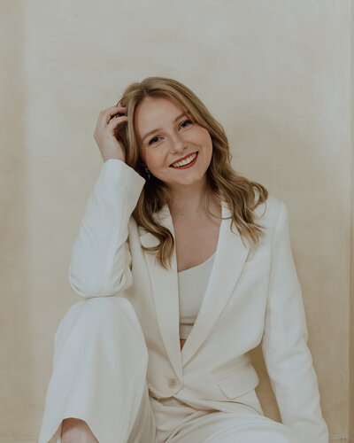 woman wearing white blazer smiling at camera