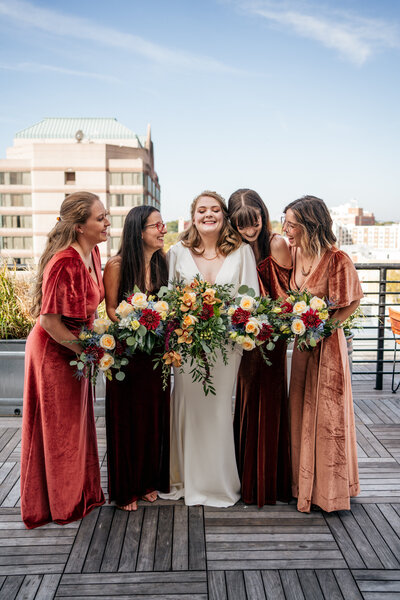 bride laughing with bridesmaids at the Durham Hotel rooftop wedding