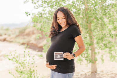 Beautiful pregnant mama holding an ultrasound picture of her baby