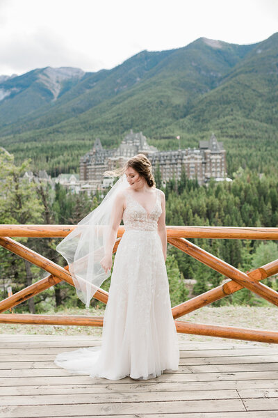 Bride standing on deck in front of Rocky Mountains