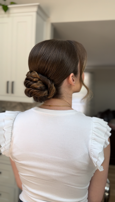 Bride with an elegant low bun and glossy, smooth finish — sophisticated wedding day hair by Klover Beauty in Maryland.