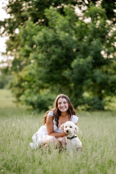 Senior girl from Hamilton Southeastern High School sitting beside her goldendoodle