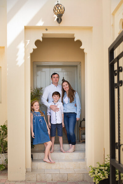 Family standing at the entrance of their house for photo session in Vancouver British Columbia by Yuliia Terziian Photography