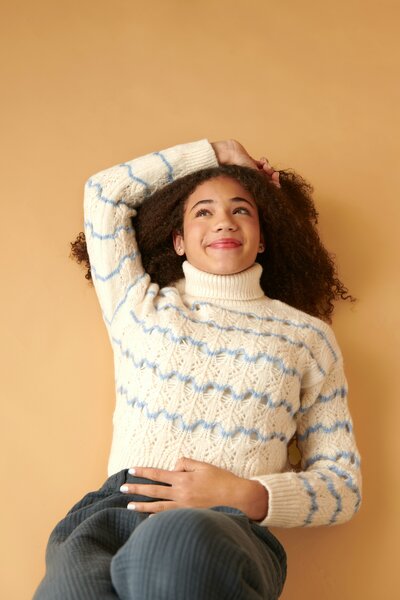 teen girl laying on floor smiling