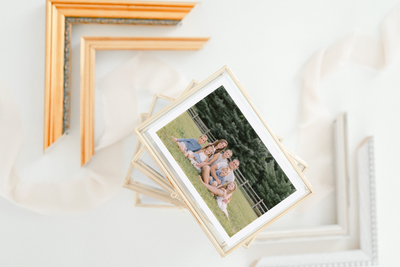 A framed family photo surrounded by elegant frame corners on a white surface — Raleigh portrait photography.