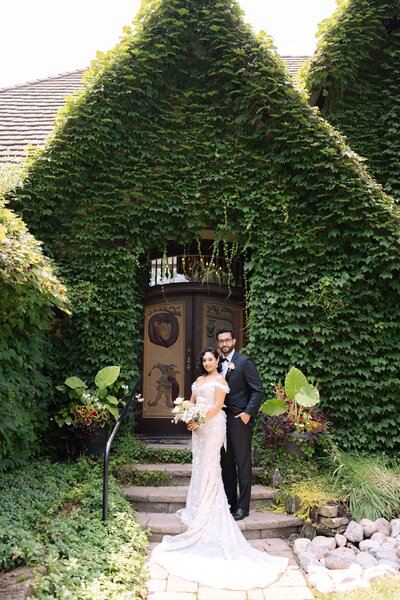 Elegant wedding portrait on stairs with Ivy wall background