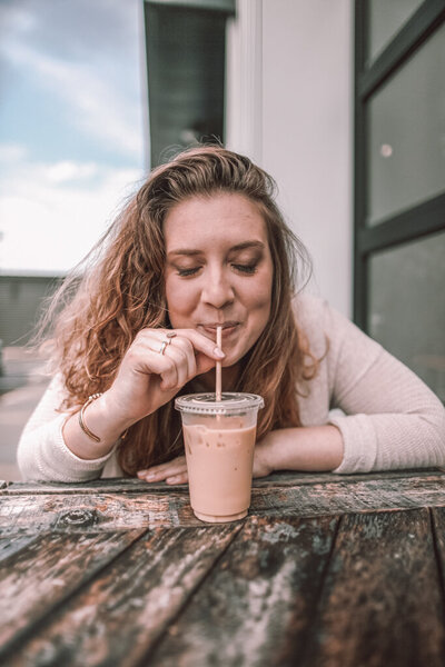 woman sipping iced coffee outside