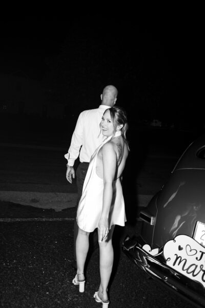 bride and groom with getaway car