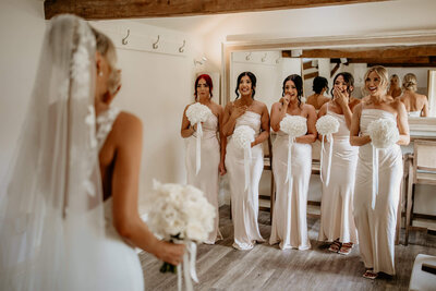 Bridesmaids reacting to the bride in the elegant dressing room at Caswell House