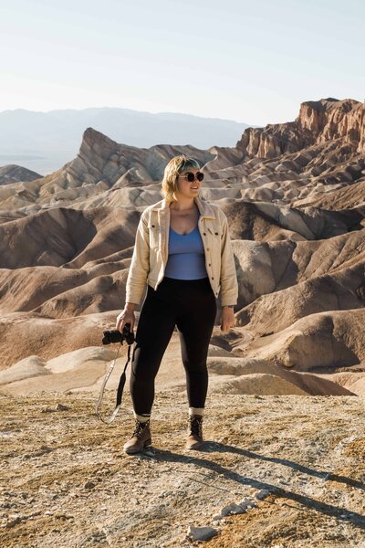 Kirstin of Wild Sol Photo Co. in Death Valley holding a camera