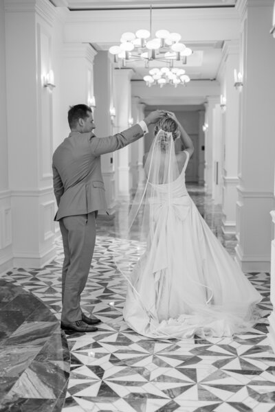 Groom twirls his bride inside of the hallway of their Ritz Carlton wedding celebration, captured by Sarasota Florida photographer