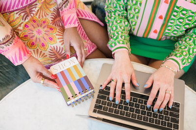 Dr. Brooks' and Dr. Templetons' hands holding a notebook and typing on a laptop