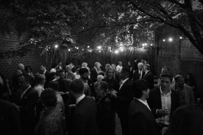 Black and white image of wedding reception under string lights