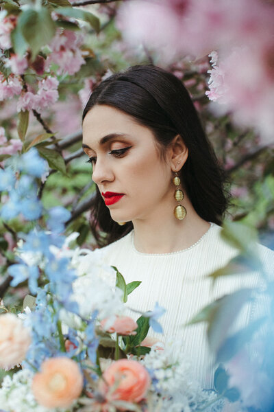 spring central park elopement with cherry blossoms and blue flowers red lip