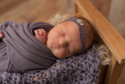 Baby girl wrapped in dusty lilac purple with matching headband