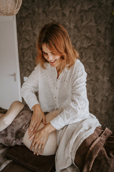 Vrouw masseert zwangere buik