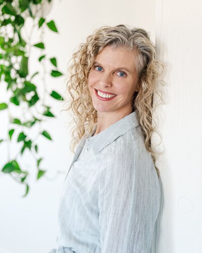Professional headshot of a smiling woman wearing a white blouse