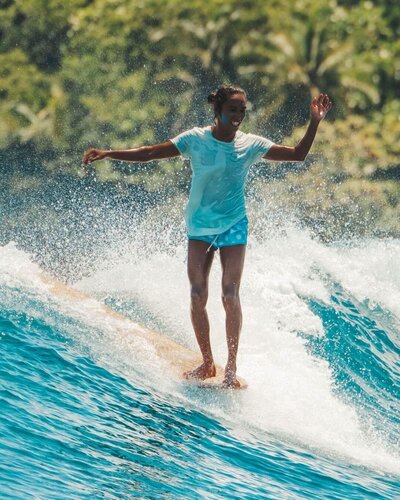 longboard surfer hangs 10 in glassy siargao waves