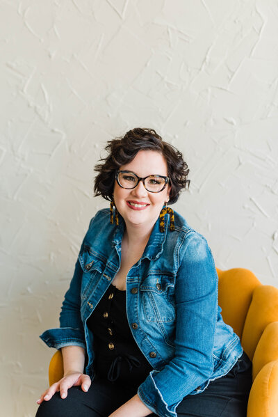 Copywriter Sara Gillis sitting on a yellow chair