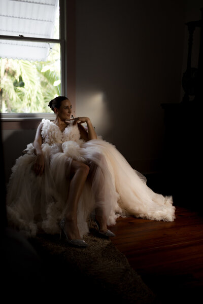 bride-in-a-peach-wedding-gown-sitting-in-a-chair