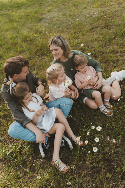 Familie knuffelt en speelt op een mooi grasveld