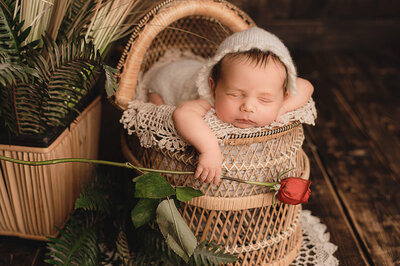 dark haired baby girl in beige frilly dress sleeping in outdoor session.
