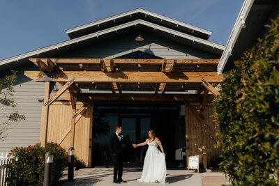 Bride and groom hold hands side by side and smile at each other at hope barn Phoenix