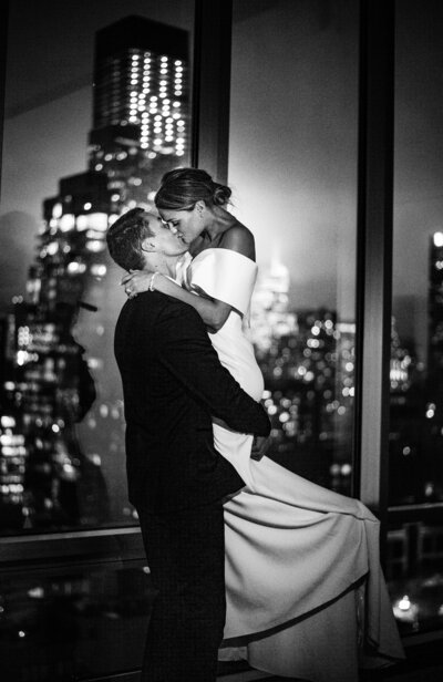 young couple enjoying a kiss with city background.
