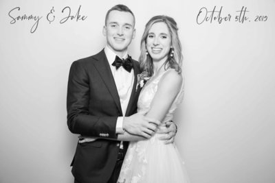beautiful couple posing on a white backdrop with a black and white glam filter