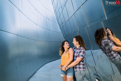 Engaged couple smile at each other during engagement session at Walt Disney Concert Hall in LA