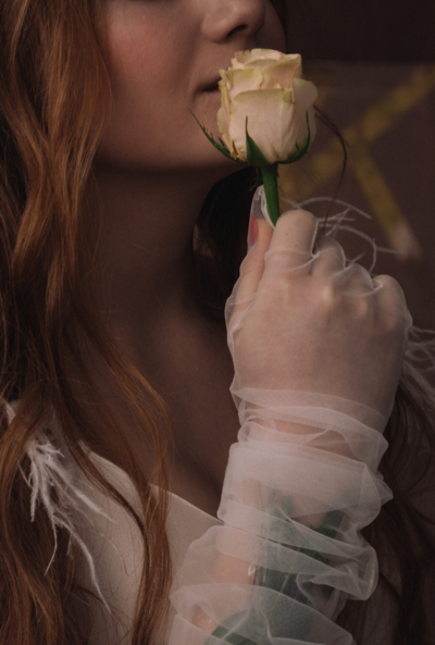 a closeup shot of a woman's hand holding a white rose