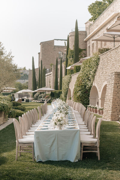 Long rectangular wedding dinner table in a terraced garden at Bastide de Gordes overlooking the Luberon Valley