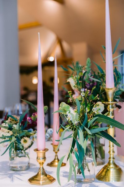 Roze lange kaarsen in gouden kandelaars op een winter wedding