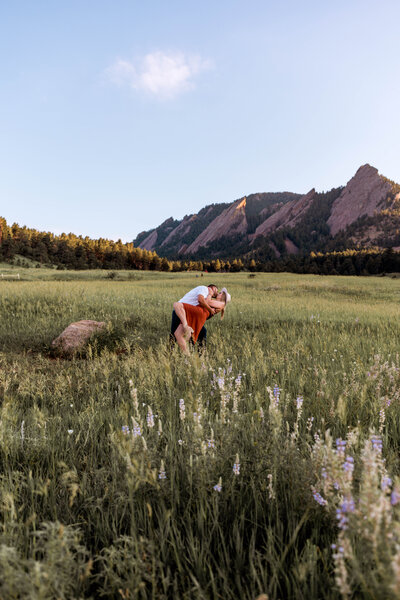 couple dipping down in field