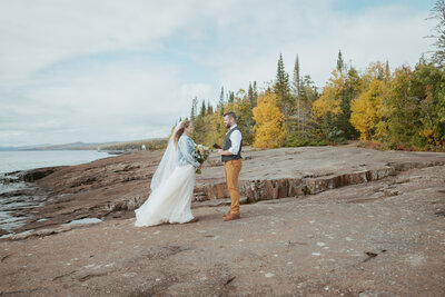 minnesota elopement couple stand on cliff by Lake Superior
