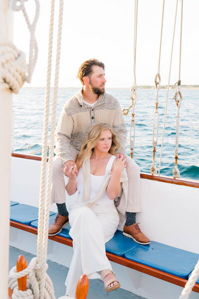 Newport Wedding Photographer | Rhode Island Caprio Captured Photography | Couple Sitting At A Sailboat Looking At The Ocean