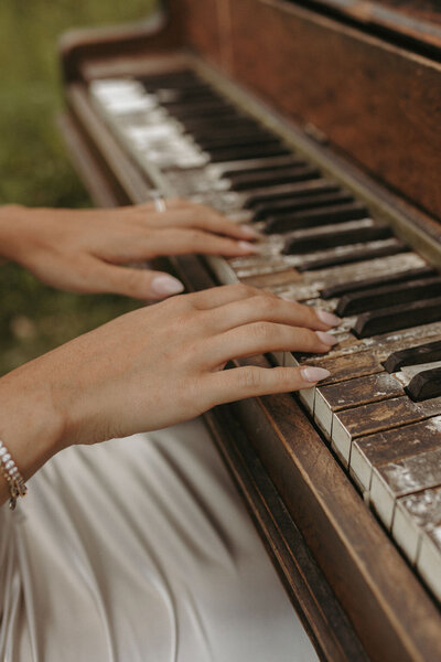 Couple playing piano together in an open field during their Michigan session