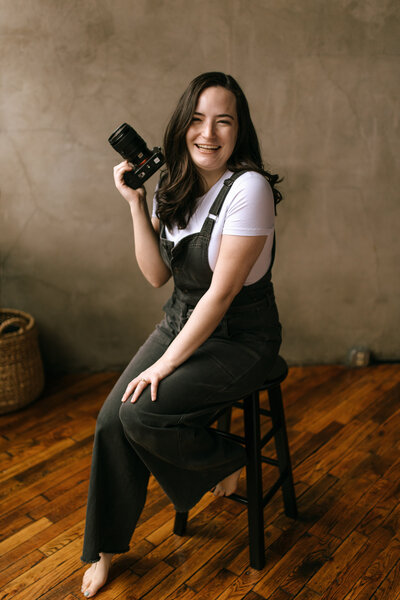 photographer sits on stool