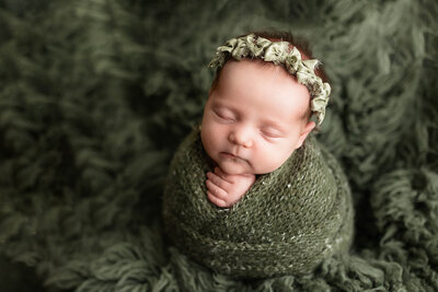 Newborn twins posed on white fur during their baby photos session in Minnesota.
