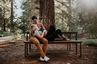 couple cuddling on park bench
